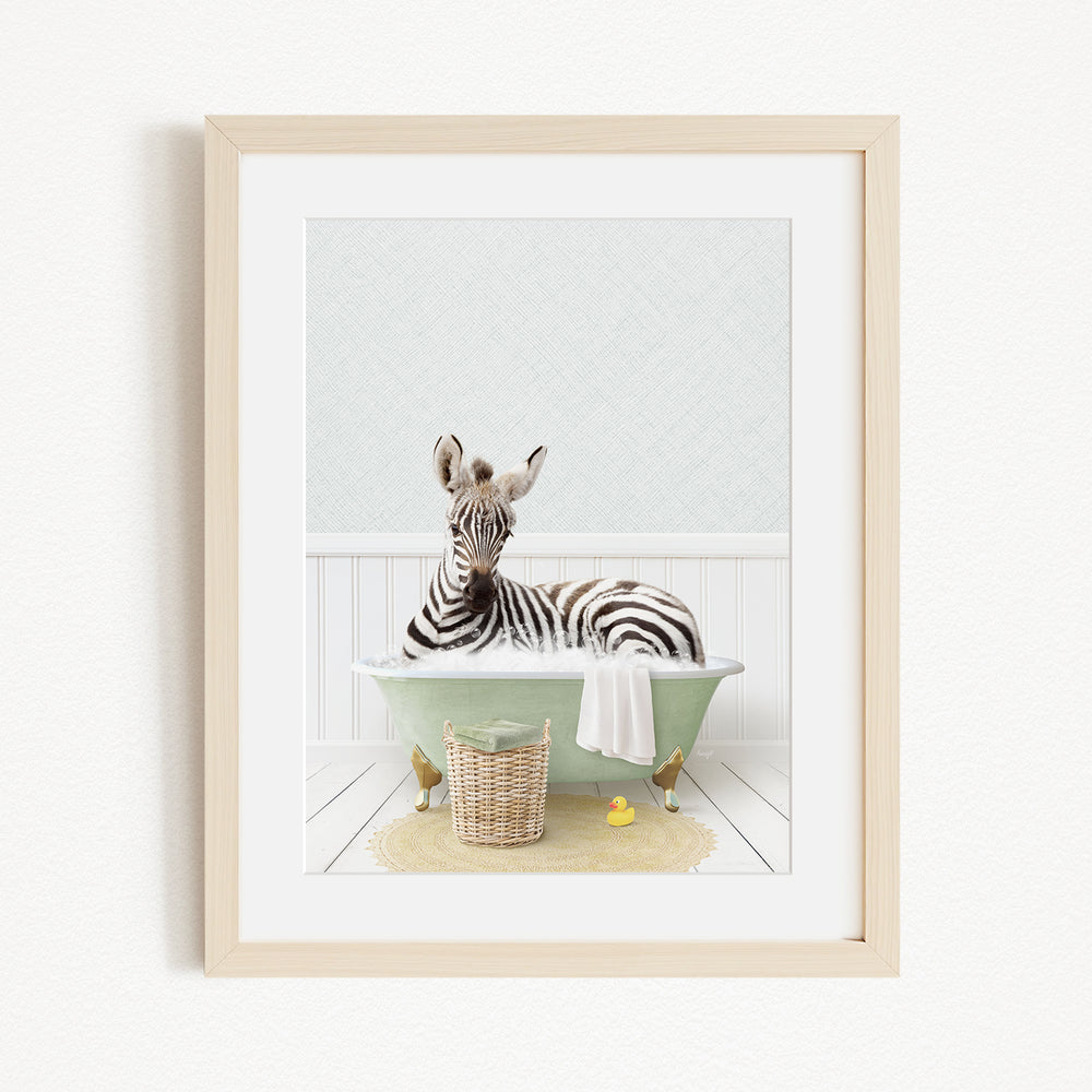 A zebra is sitting in a green bathtub filled with water, surrounded by a basket of toys and a yellow rubber ducky.