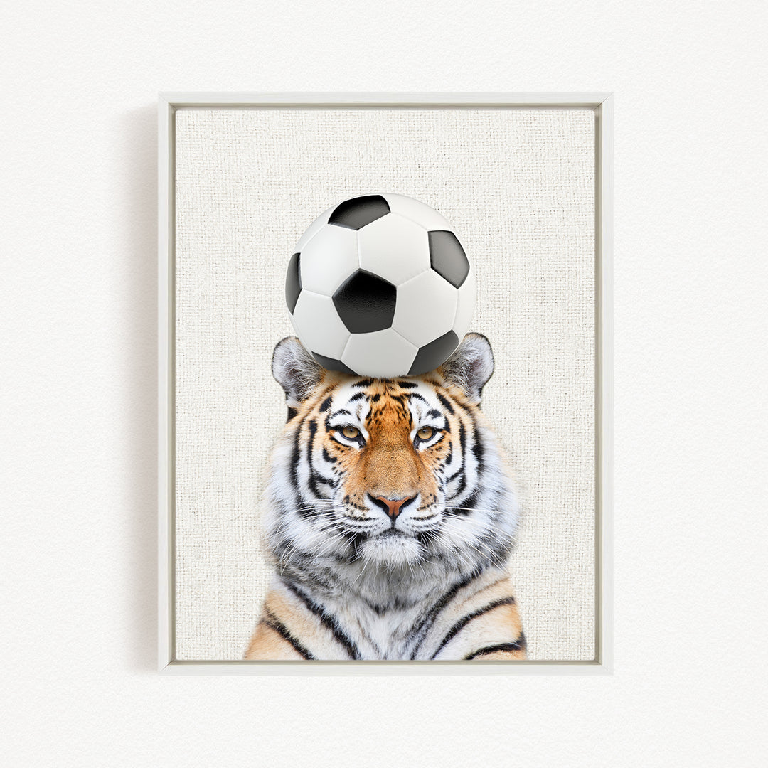 A tiger is sitting on a soccer ball, with the ball balanced on its head.