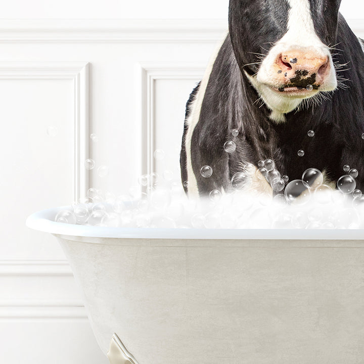 a black and white cow standing in a bathtub full of bubbles