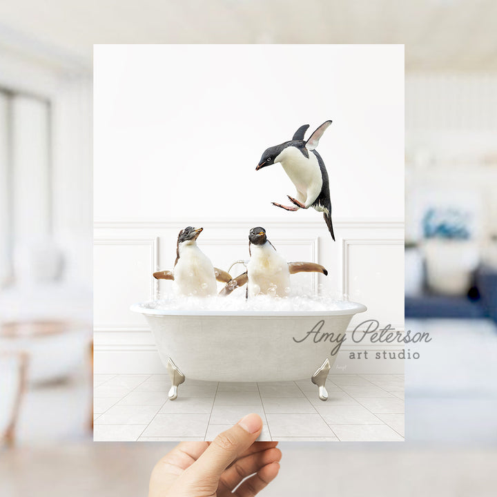 a hand holding up a card with penguins in a bathtub