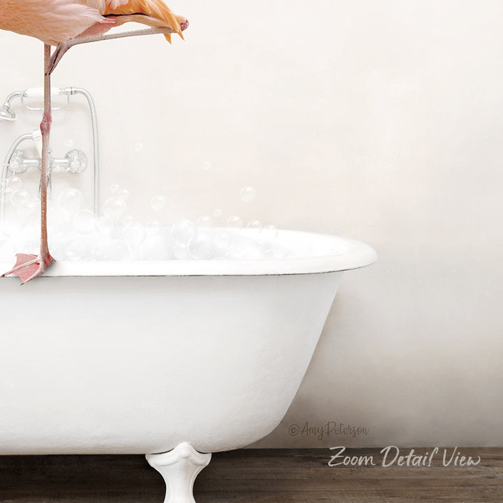 A white claw-foot bathtub filled with bubbles, with a pink flamingo perched on the edge.