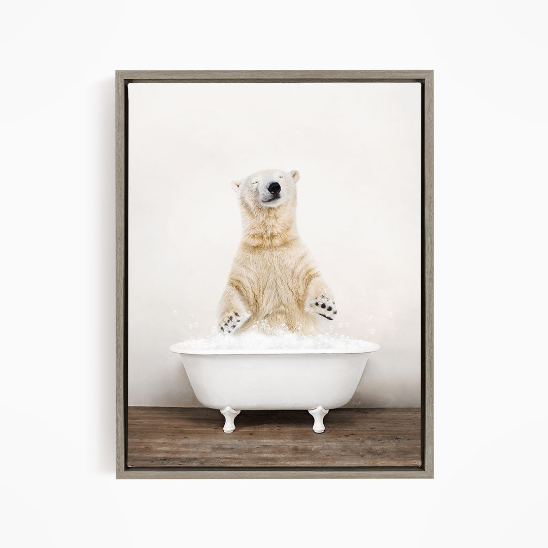 A polar bear sitting in a white bathtub filled with water, appearing to be enjoying a bath.
