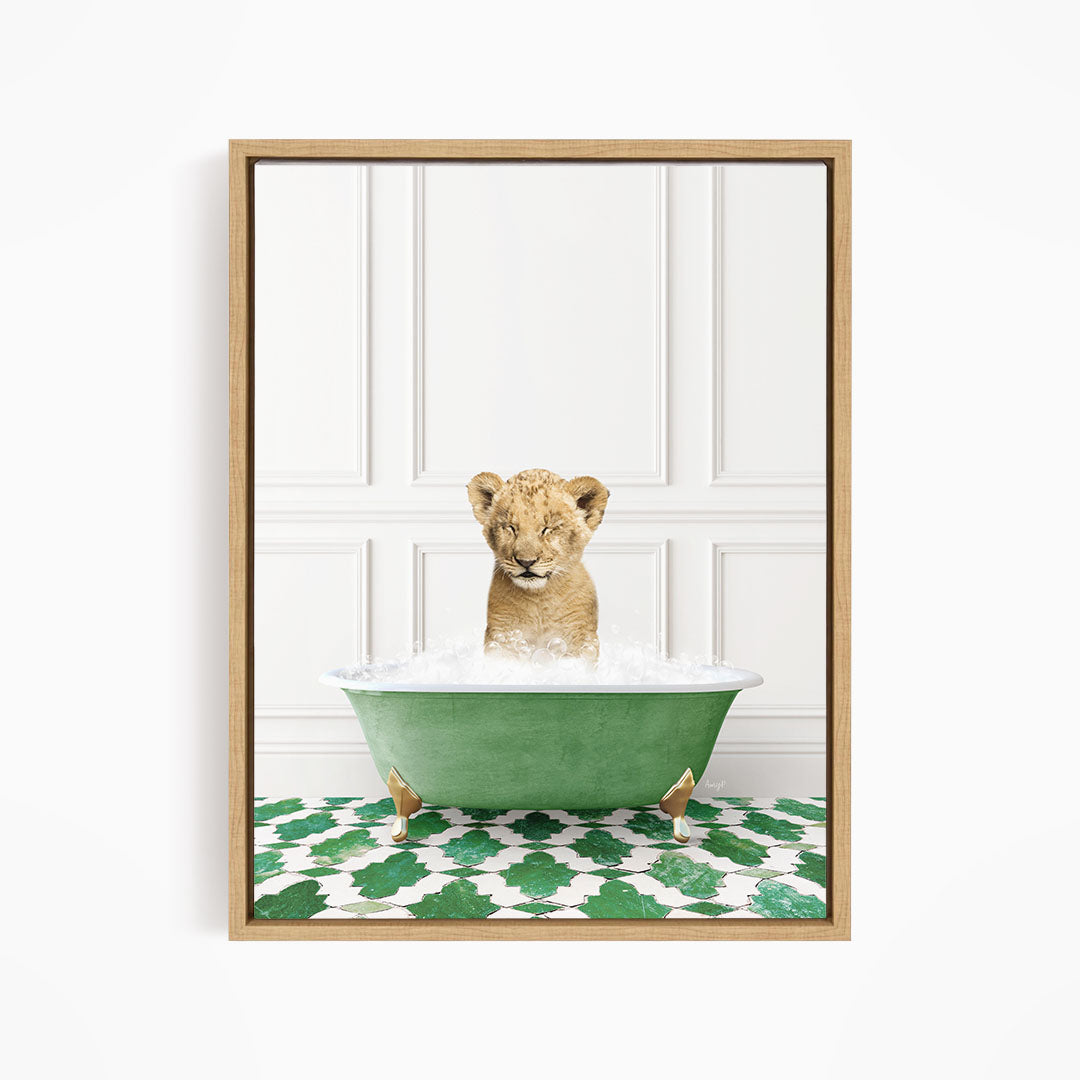 A young lion cub is sitting in a green bathtub filled with water, surrounded by a green and white patterned floor.