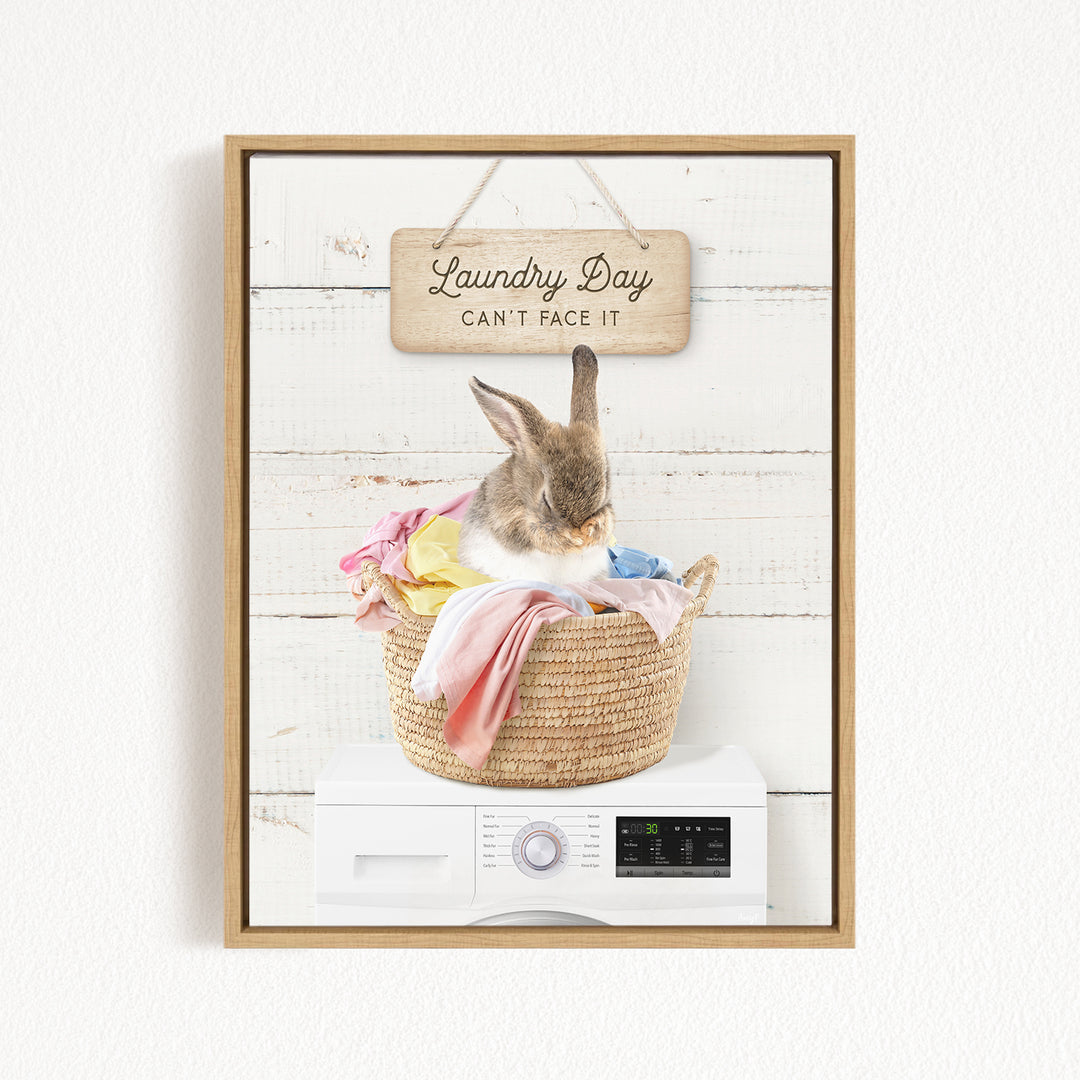 A cute rabbit sitting in a woven laundry basket, with a sign above that says "Laundry Day Can't Face It".