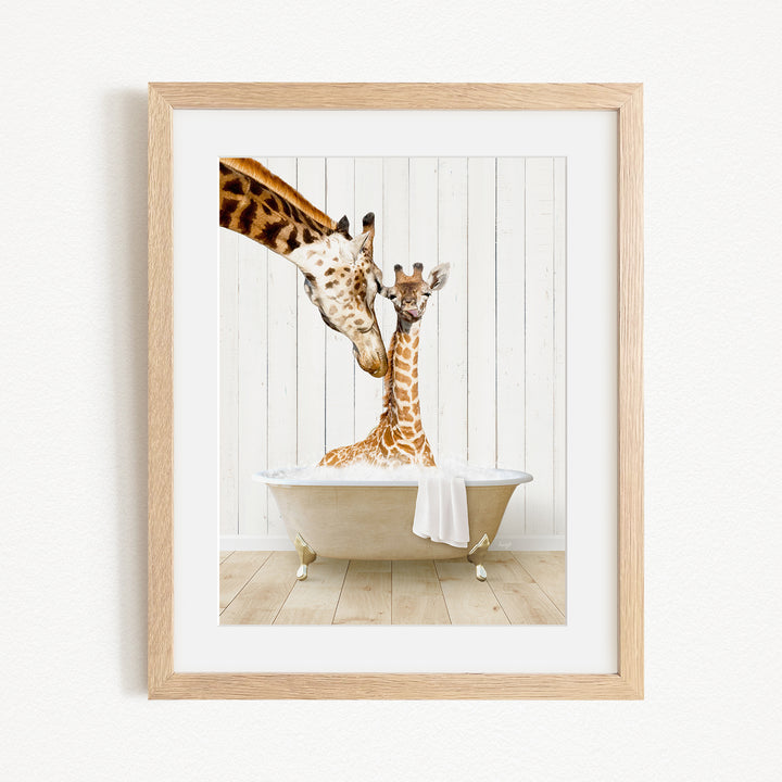 A mother giraffe and her baby giraffe are sitting together in a bathtub, with the mother gently licking her baby.