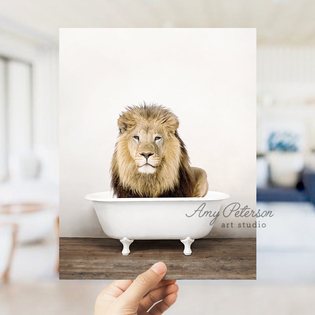 a hand holding a photo of a lion in a bathtub