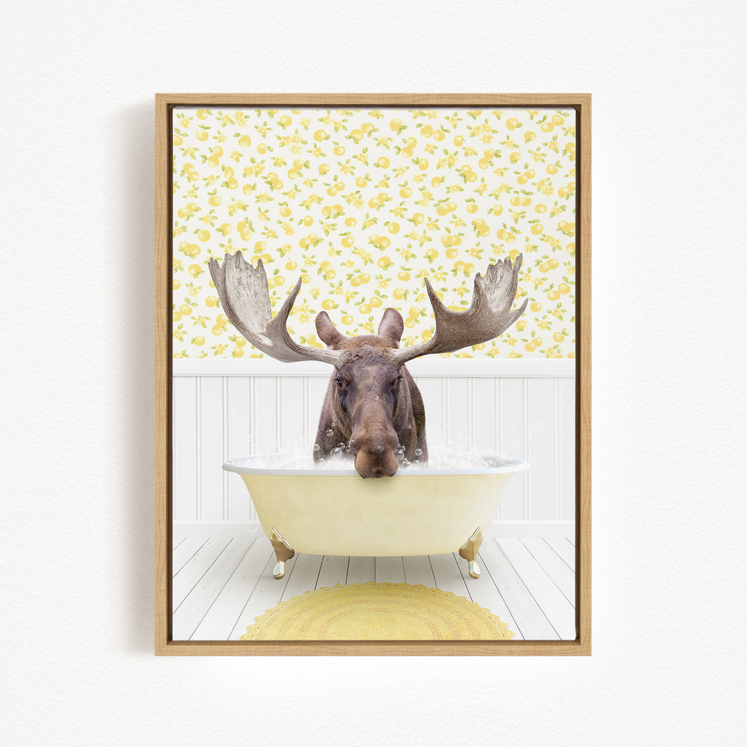 A moose with large antlers is sitting in a bathtub filled with water, surrounded by a yellow floral pattern on the wall behind it.