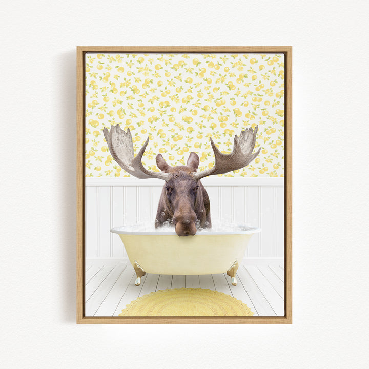 A moose with large antlers is sitting in a bathtub filled with water, surrounded by a yellow floral pattern on the wall behind it.