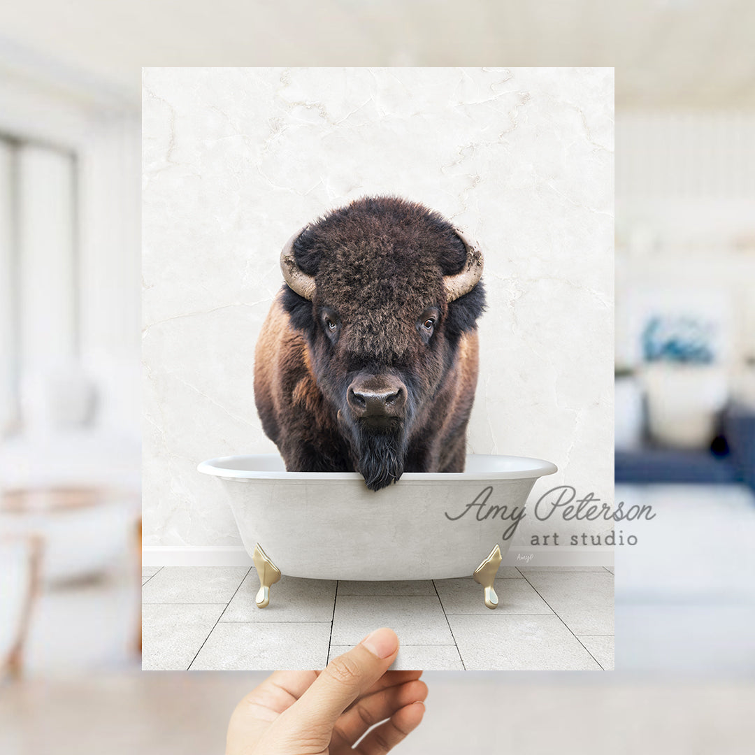 a hand holding a photo of a bison in a bathtub