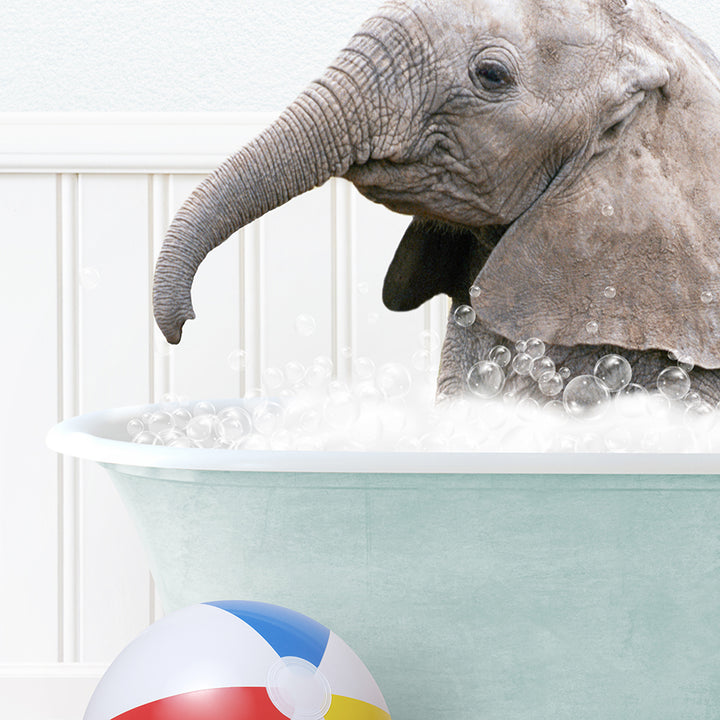 an elephant in a bathtub with bubbles and a beach ball