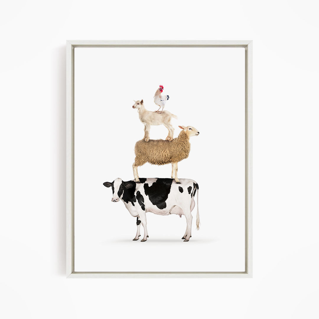 A framed image depicting a cow, sheep, and chicken stacked on top of each other.