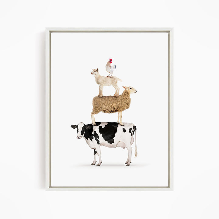 A framed image depicting a cow, sheep, and chicken stacked on top of each other.