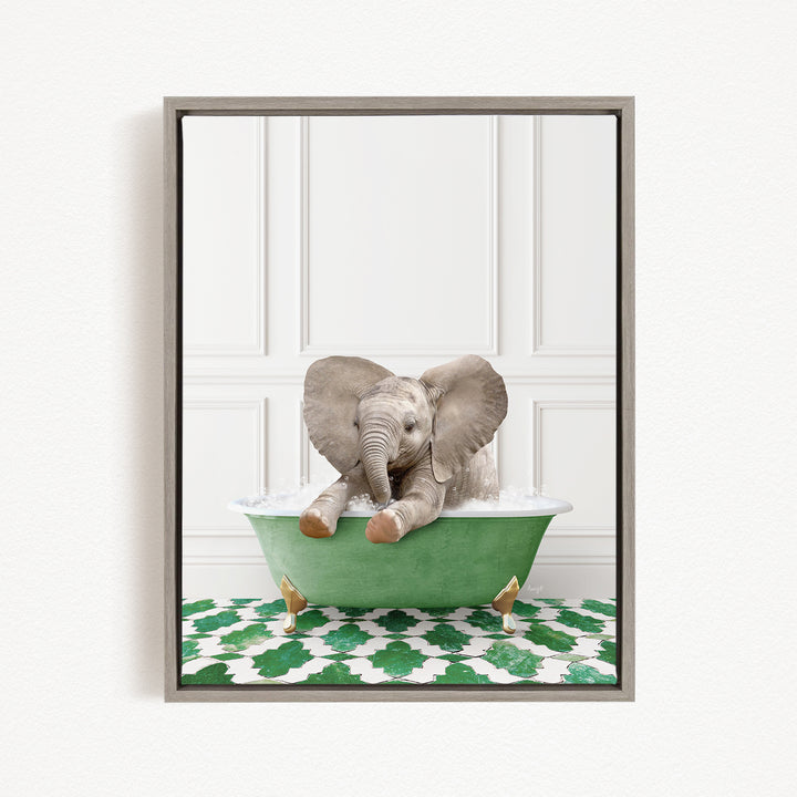 A gray elephant is sitting in a green bathtub, surrounded by a green and white patterned mat.