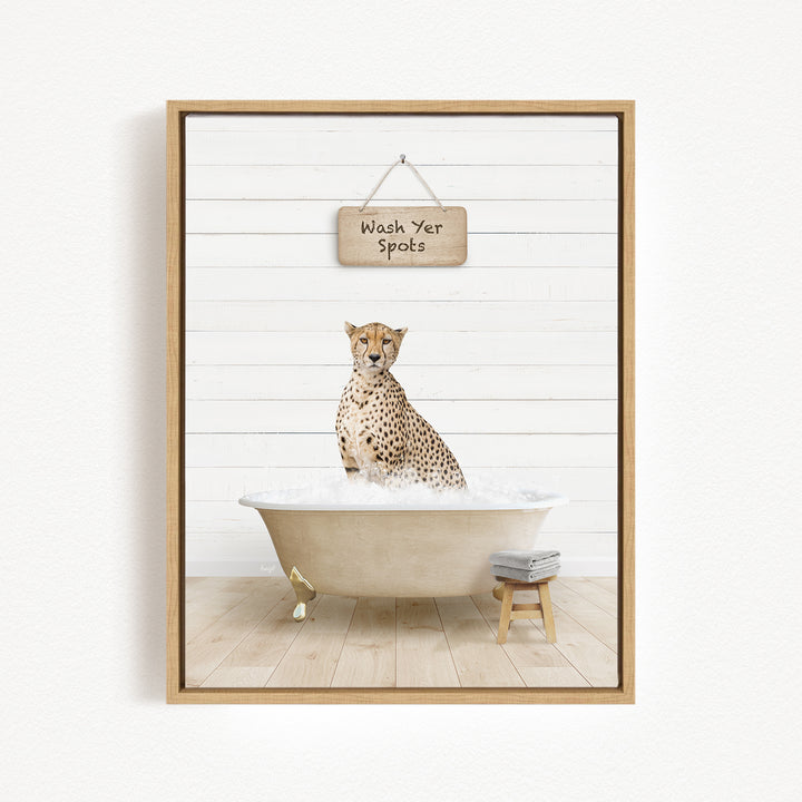 A cheetah sitting in a bathtub filled with water, with a sign above that reads "Wash Your Spots".