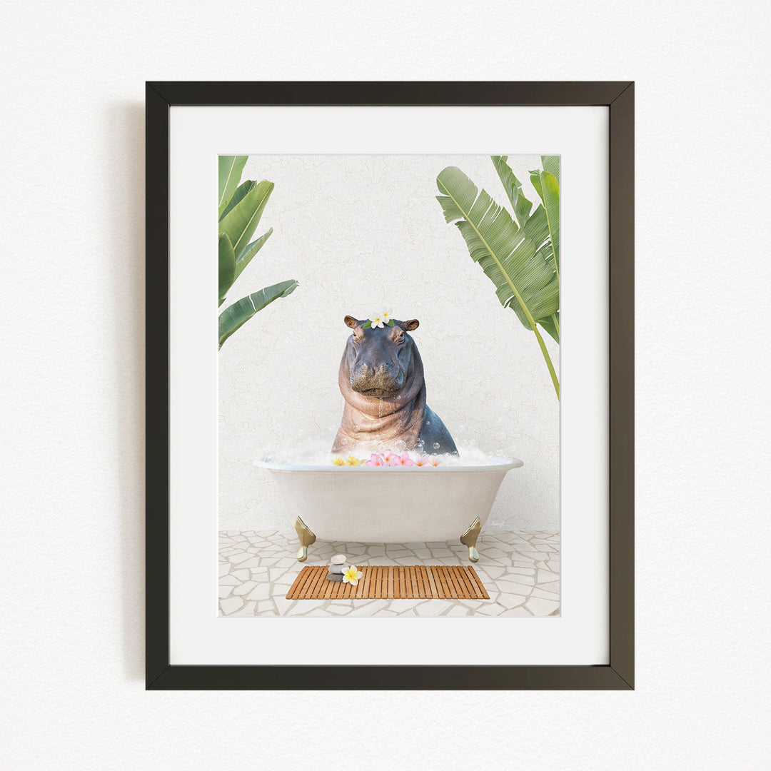 A framed image depicting a hippopotamus sitting in a bathtub filled with bubbles, surrounded by tropical plants.