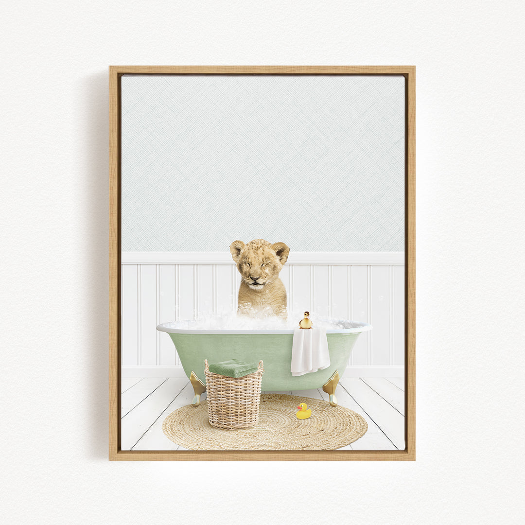 A young lion cub sitting in a green bathtub filled with water, surrounded by a basket of toys and a yellow rubber duck.