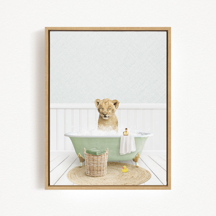 A young lion cub sitting in a green bathtub filled with water, surrounded by a basket of toys and a yellow rubber duck.