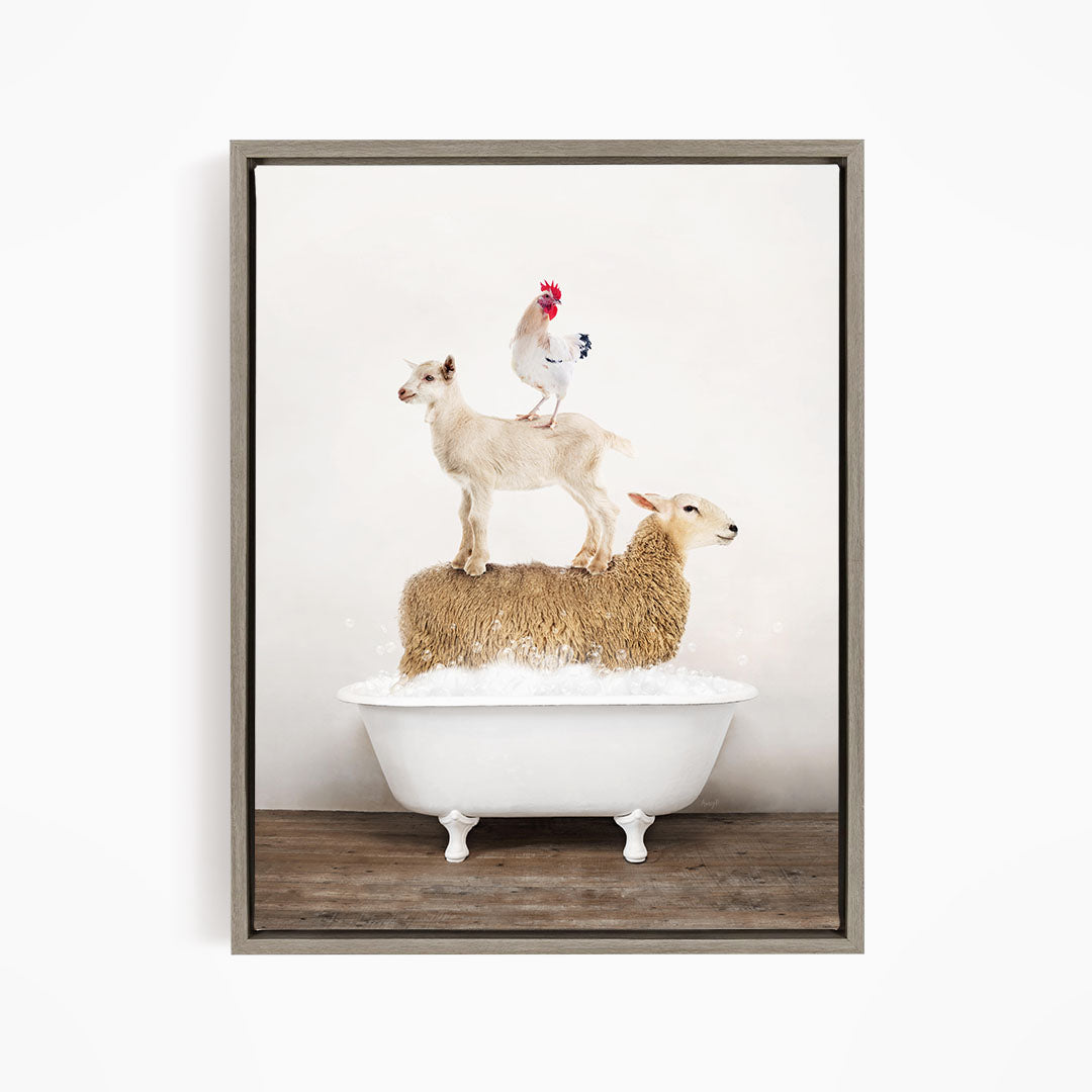 A framed image depicting a white goat standing on the back of a sheep in a bathtub, with a rooster perched on top of the sheep.