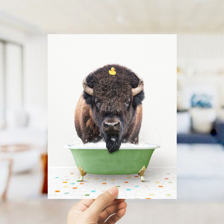 A buffalo with a yellow rubber duck sitting in a green bathtub.
