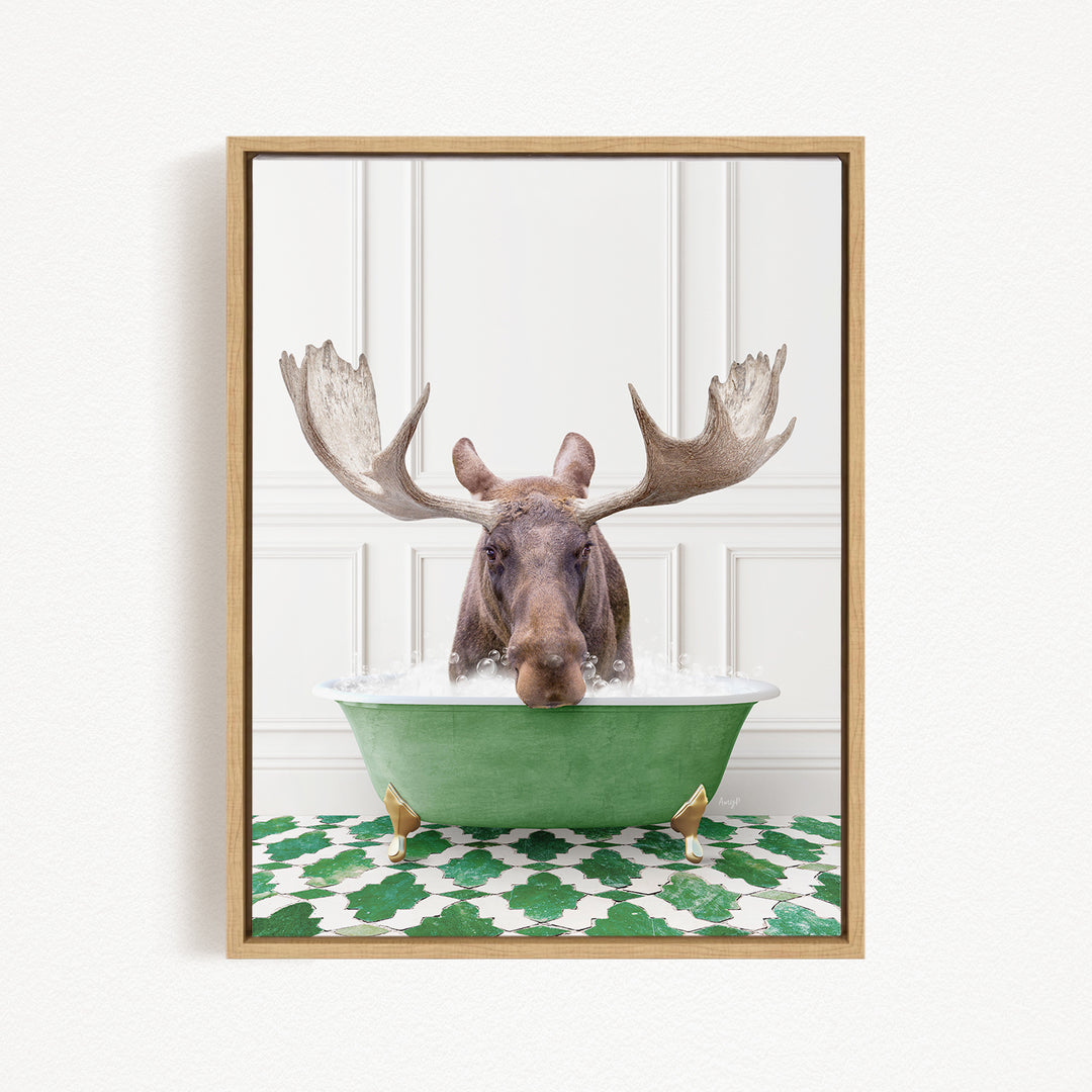 A moose with large antlers is sitting in a green bathtub filled with water, creating a whimsical and humorous scene.