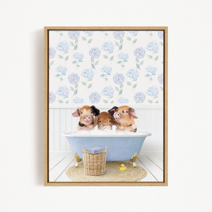 Three adorable pigs sitting in a blue bathtub, surrounded by a floral patterned wall and a basket of rubber ducks.
