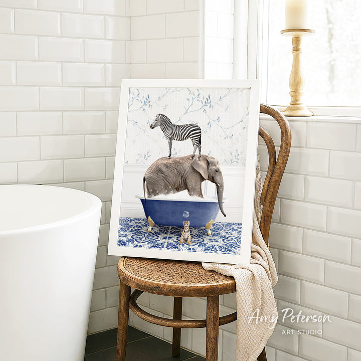 A framed image of a zebra standing on an elephant in a blue bathtub, placed on a wooden chair in a bathroom setting.