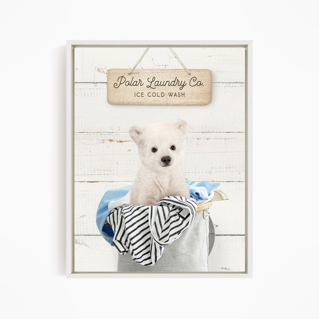 A white polar bear sitting in a laundry basket, with a wooden sign above that reads "Polar Laundry Co. Ice Cold Wash".
