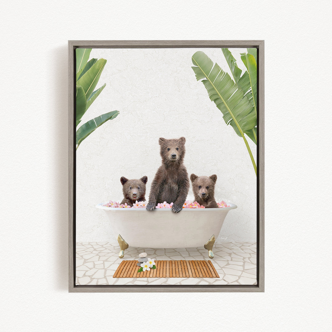 A framed image depicting three bears sitting in a bathtub filled with pink flowers, surrounded by green leaves.