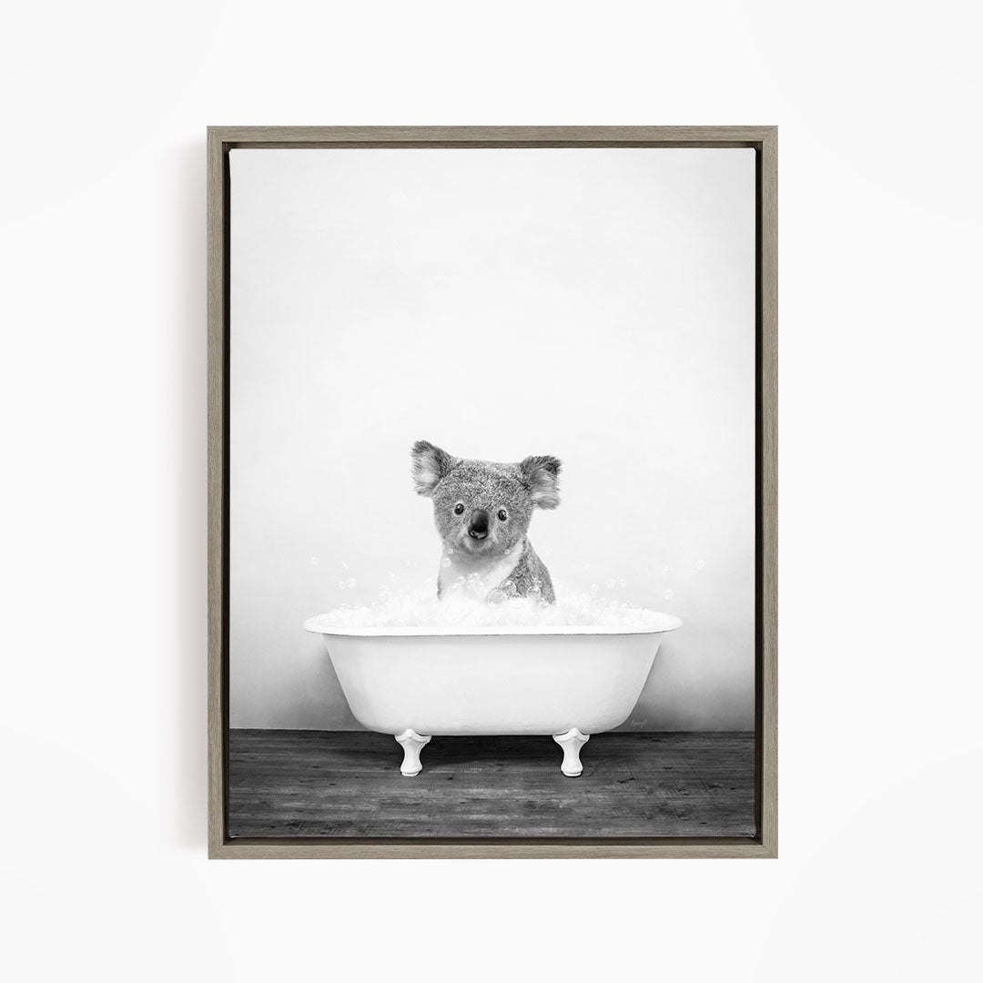 A koala sitting in a bathtub filled with water, looking directly at the camera.