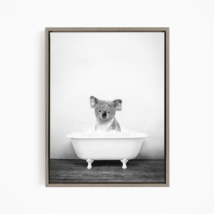 A koala sitting in a bathtub filled with water, looking directly at the camera.