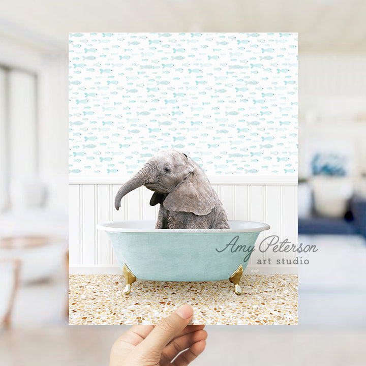 a hand holding up a picture of an elephant in a bathtub