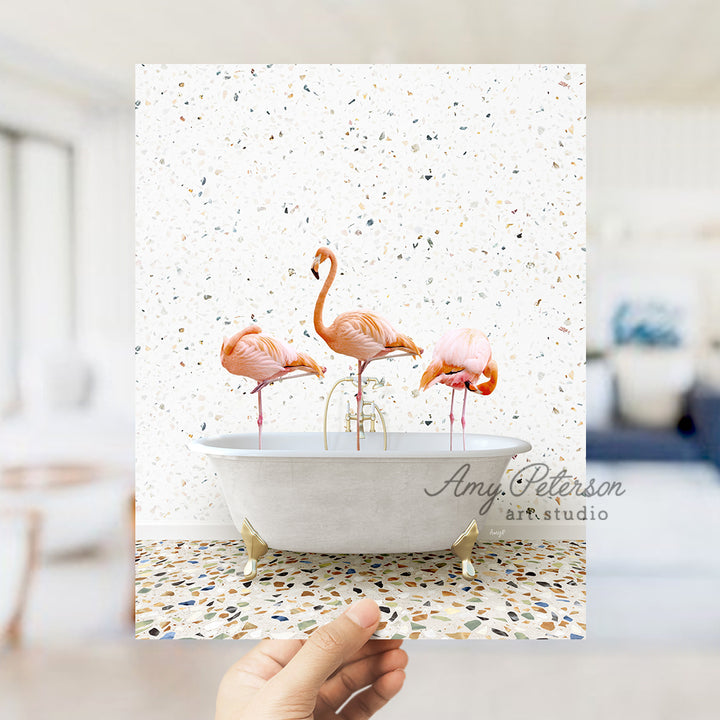 a person holding a card with three flamingos in a bathtub