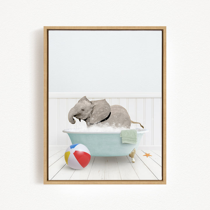 A gray elephant is sitting in a blue bathtub filled with water, surrounded by a beach ball and a towel.