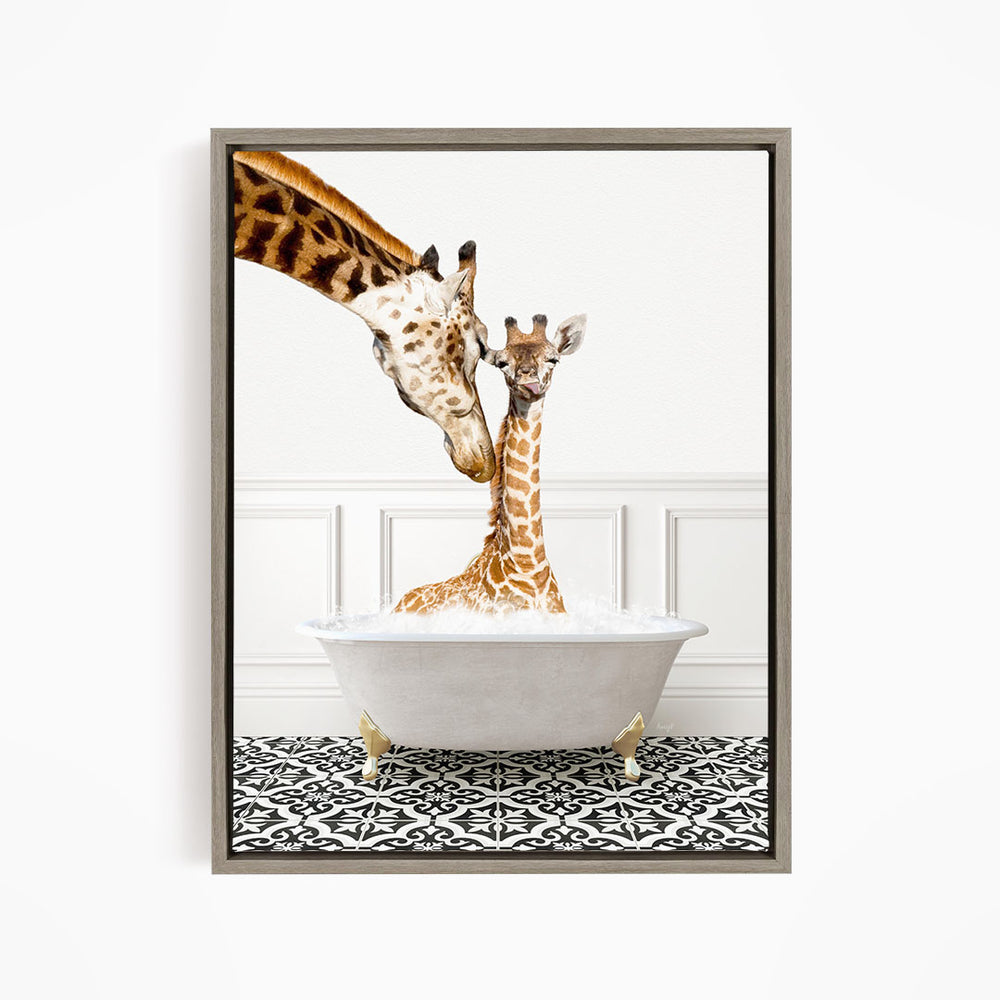 A mother giraffe and her baby giraffe are sitting together in a white bathtub, with the mother gently licking her baby.