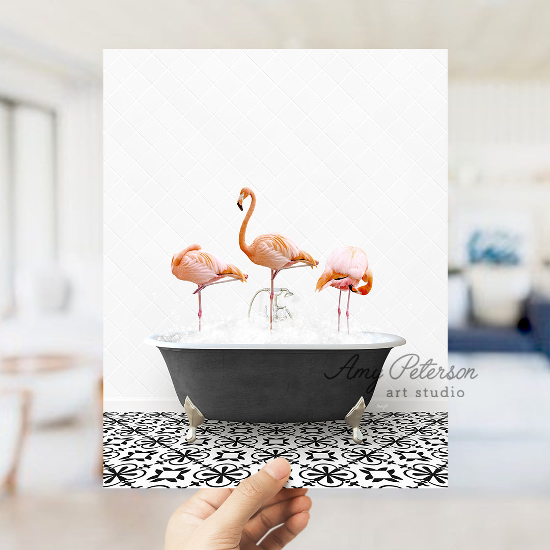 a person holding up a card with three flamingos in a bathtub