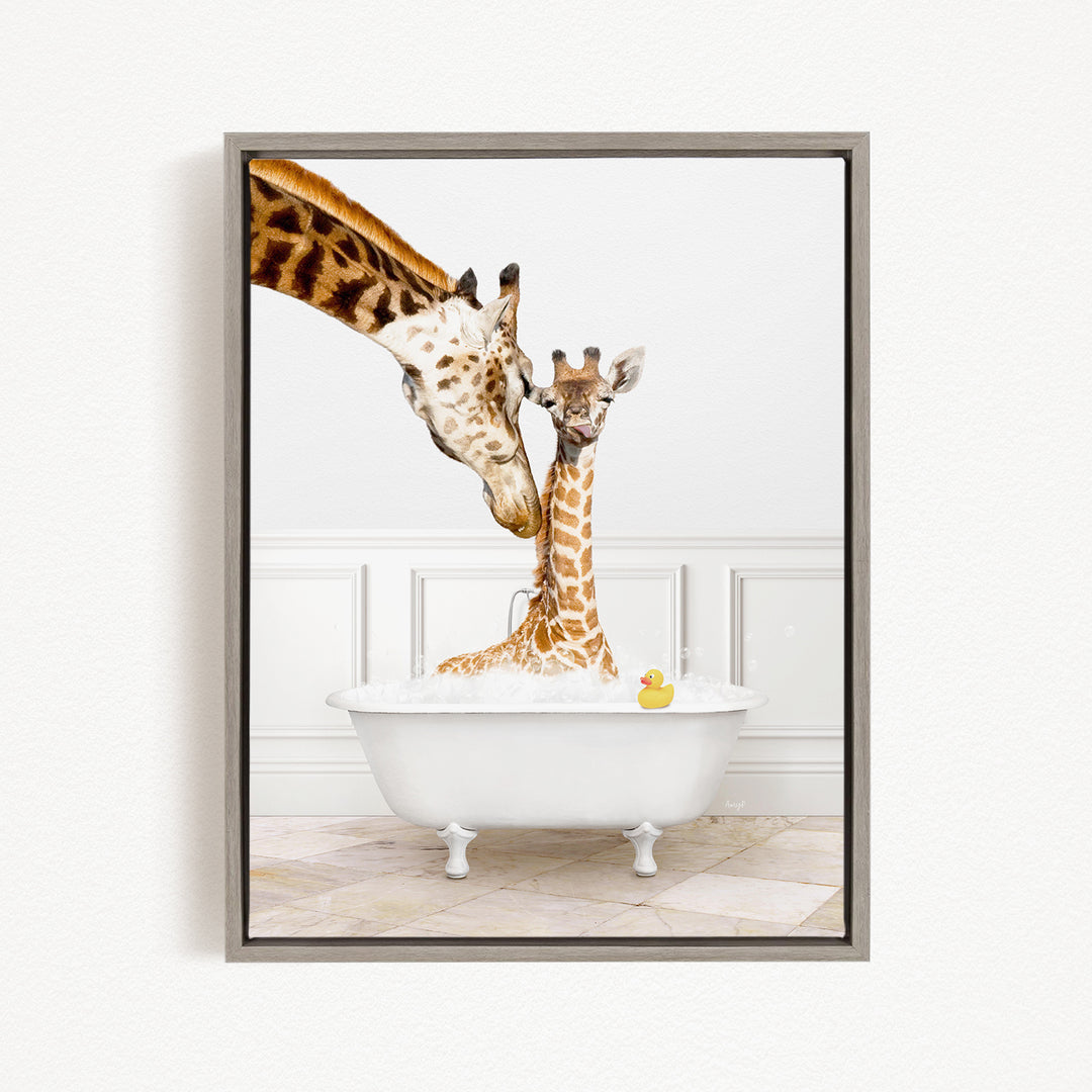 A mother giraffe and her baby giraffe are sitting together in a white bathtub, with a yellow rubber duck floating in the water.