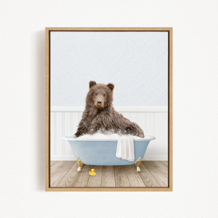 A brown bear sitting in a blue bathtub filled with bubbles, surrounded by rubber duckies.