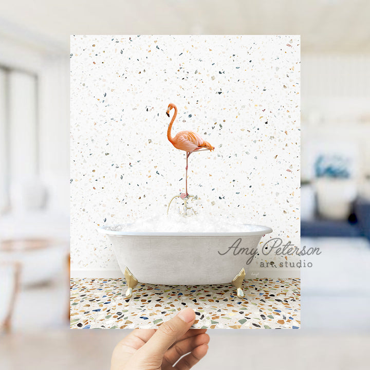 a hand holding a card with a flamingo in a bathtub