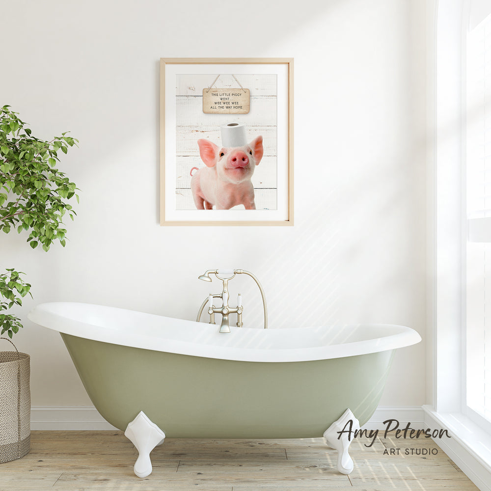 a bathroom with a green clawfoot bathtub, a framed picture of a pig with a toilet paper roll on its head, and a potted plant on the left side of the frame.