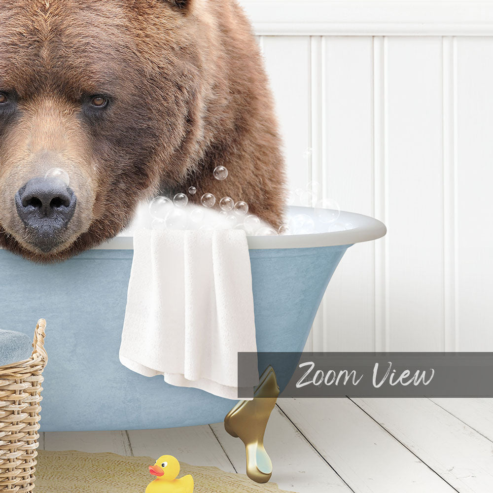A large brown bear is sitting in a blue bathtub filled with water, surrounded by a yellow rubber duck and a towel.