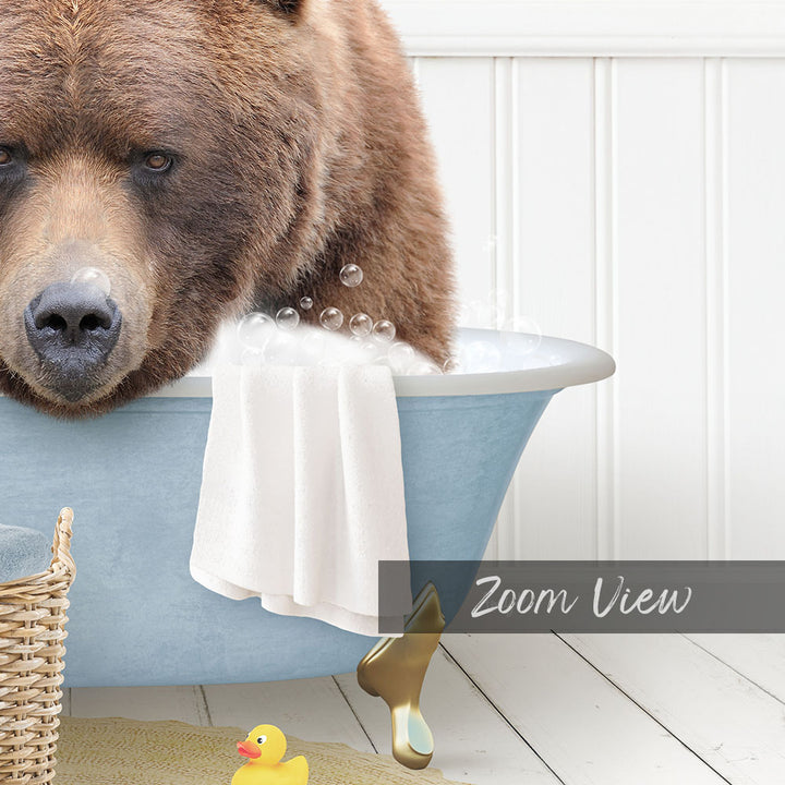 A large brown bear is sitting in a blue bathtub filled with water, surrounded by a yellow rubber duck and a towel.