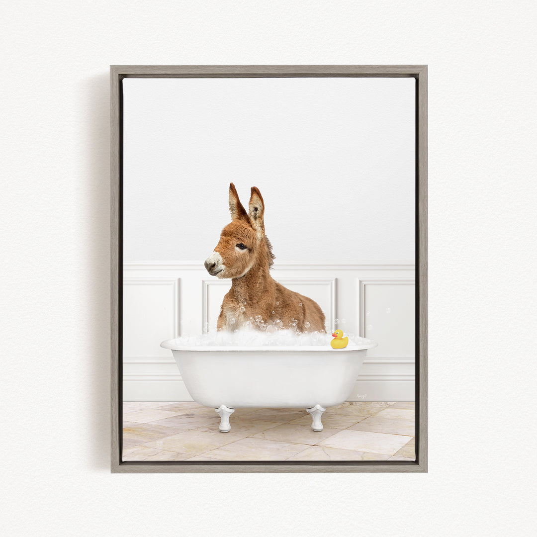A donkey is sitting in a white bathtub filled with bubbles, with a rubber duck floating in the water.