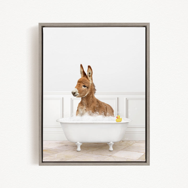 A donkey is sitting in a white bathtub filled with bubbles, with a rubber duck floating in the water.