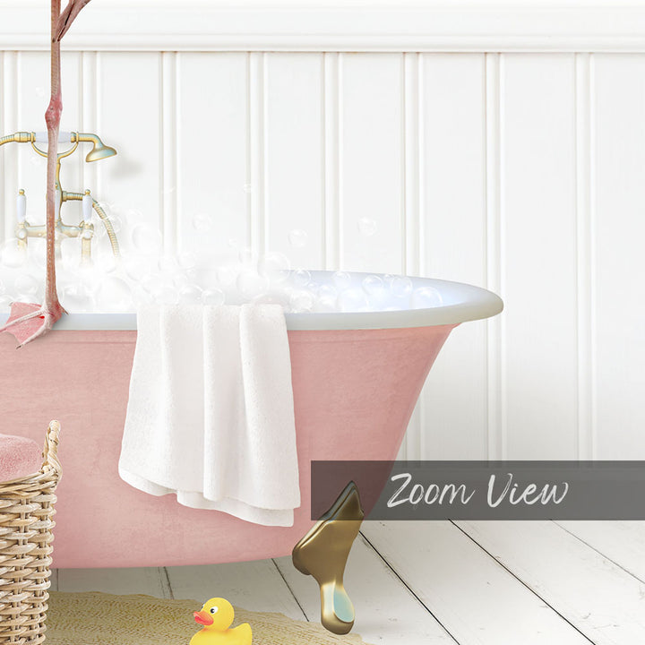 A pink claw-foot bathtub filled with bubbles, with a white towel hanging on the side and a rubber duck nearby.