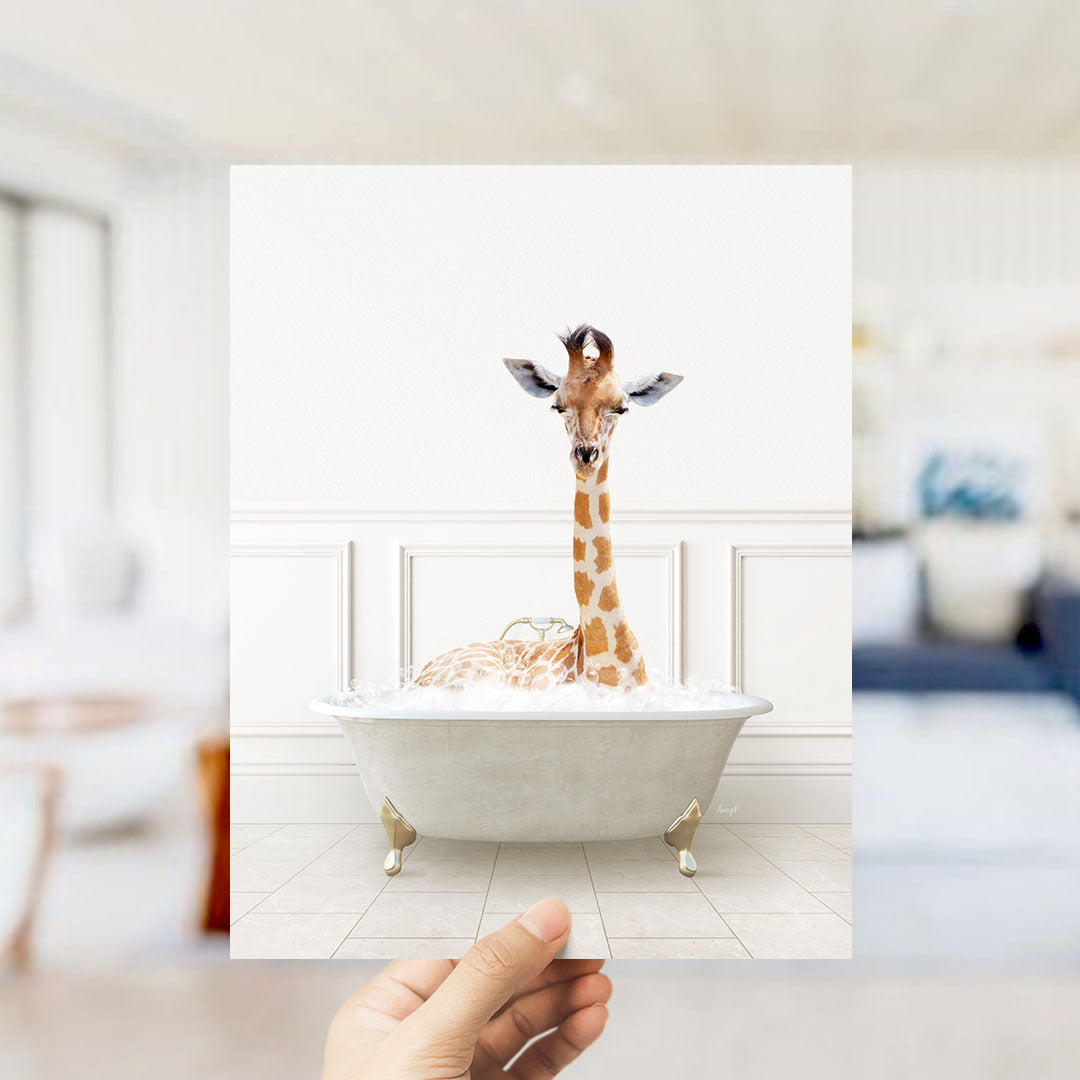 A giraffe sitting in a bathtub filled with bubbles, with a hand holding up the image to show it.