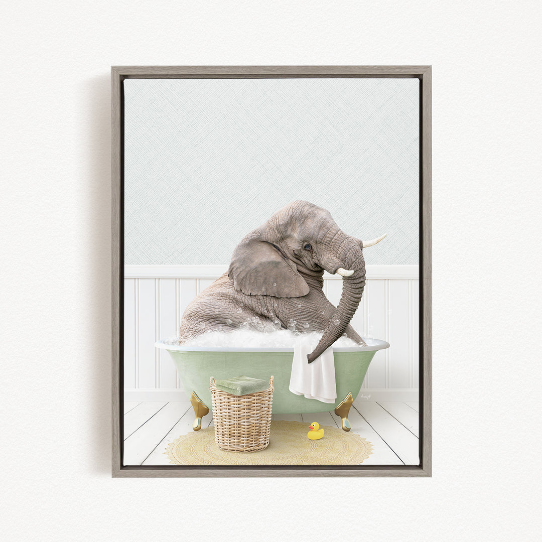 A gray elephant is sitting in a green bathtub filled with water, surrounded by a basket of toys and a yellow rubber duck.