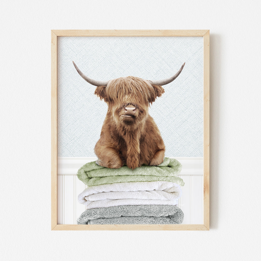 a picture of a brown cow sitting on top of a pile of towels