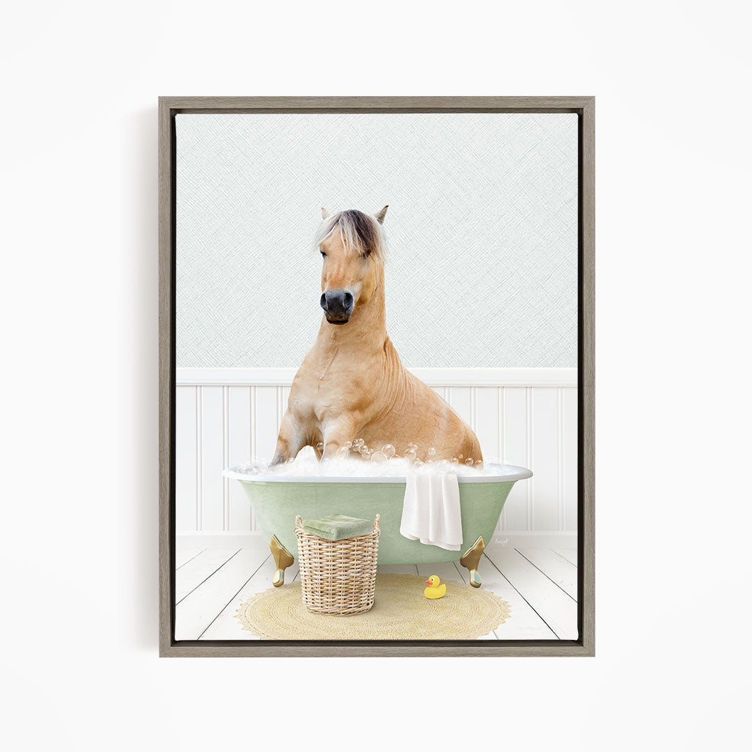A light brown horse is sitting in a green bathtub filled with bubbles, surrounded by a basket of toys and a yellow rubber duck.