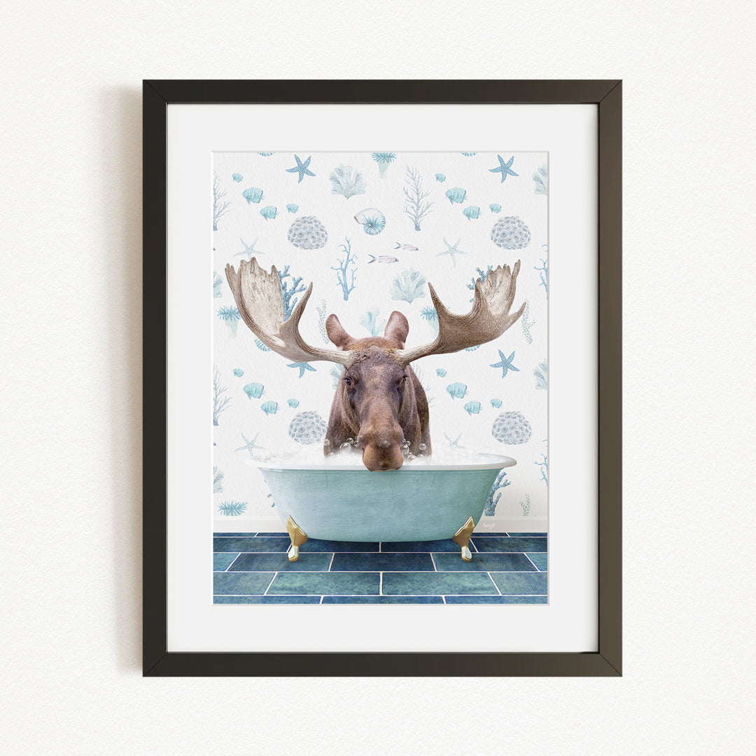 A framed image depicting a moose with large antlers sitting in a bathtub filled with bubbles, surrounded by a blue and white ocean-themed background.
