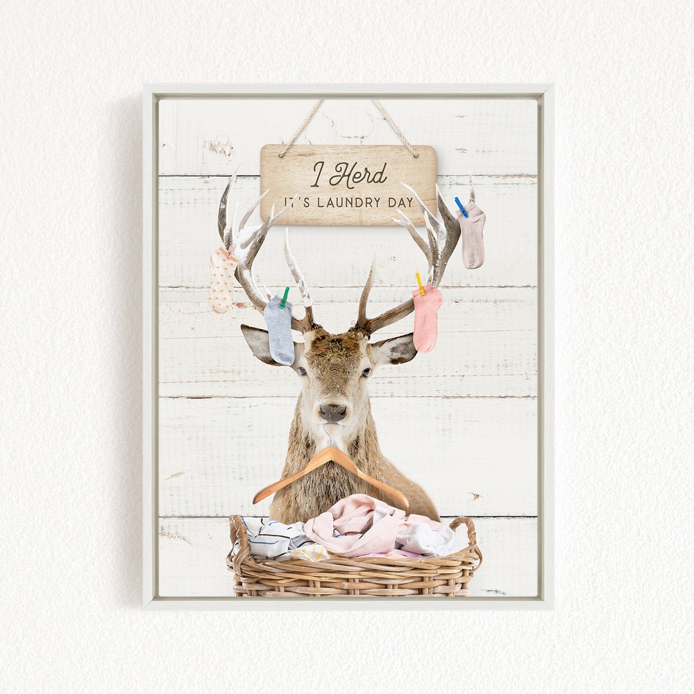 A deer with antlers is hanging laundry on a clothesline, with a sign above that says "It's laundry day".